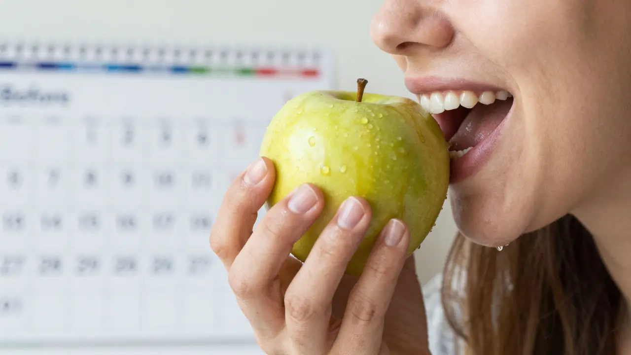 Ruce drží jablko – jedna s protézou, druhá s přirozenými zuby.